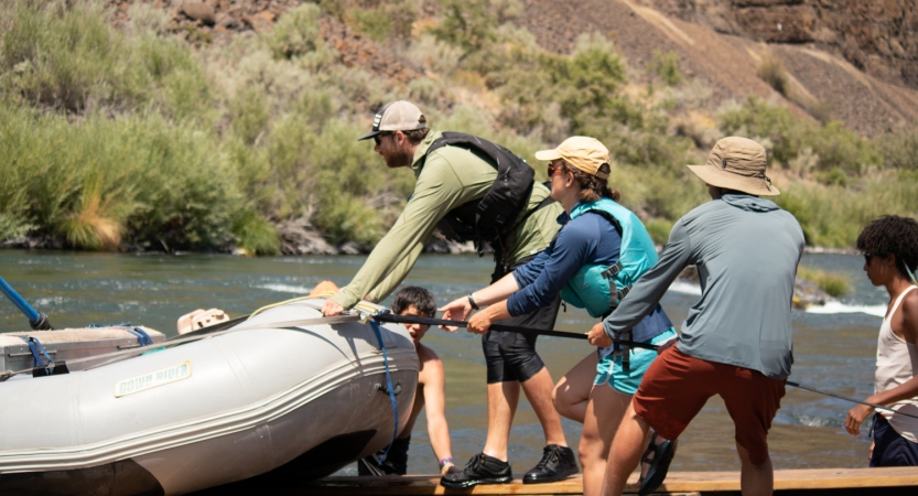 a group of students pull a raft onto a trailer during a gap year semester with outward bound